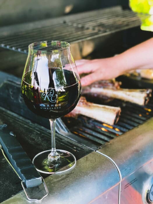 A glass of Kramer Vineyards Pinot Noir beside the grill