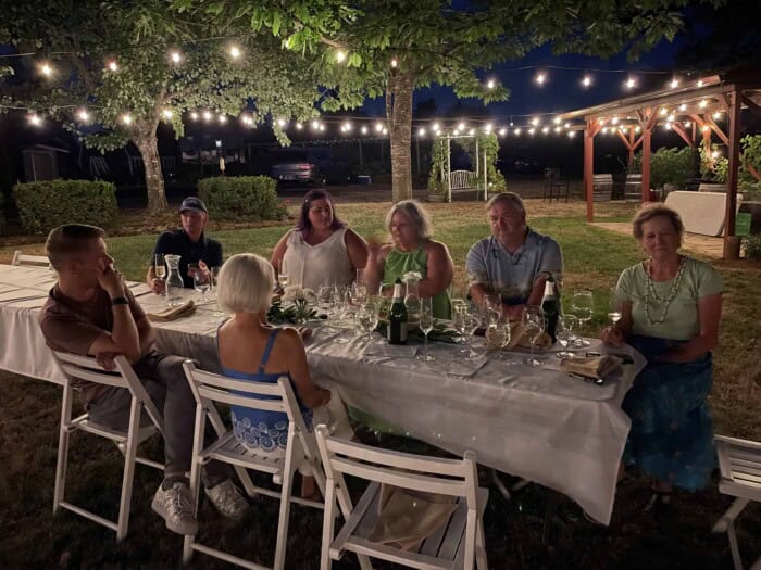 Guests gathered at a Kramer Vineyards outdoor dinner under string lights