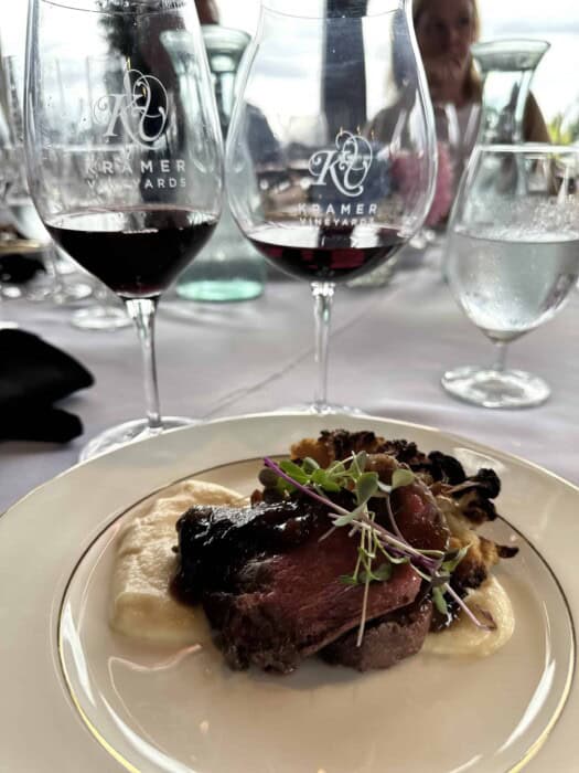 Two glasses of Kramer Vineyards Pinot Noir with a plated red-meat course