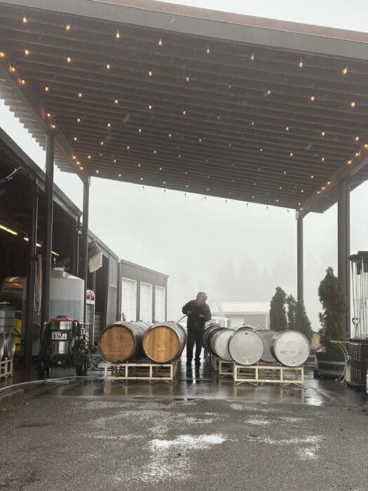 Winery staff inspecting barrels under a covered outdoor area at Kramer Vineyards.